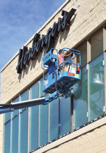 A worker installs glass at the Herbergers store in the Pine Ridge Mall.